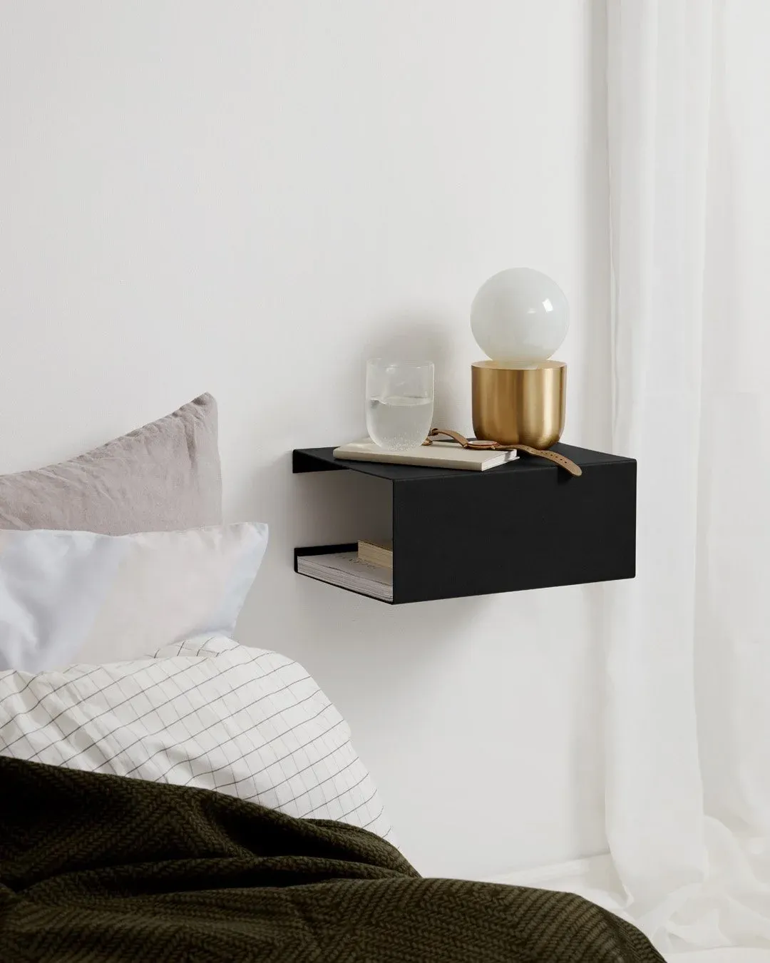 Schwarze Wandablage von ReCollector mit Tischleuchte neben einem Bett