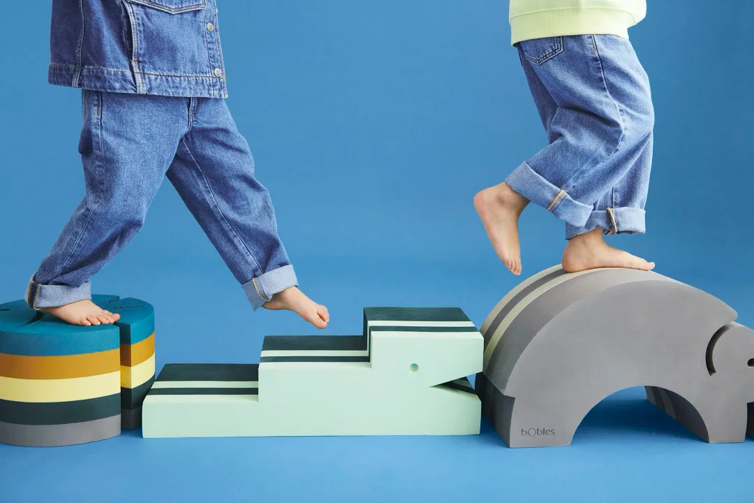 Zwei Kinder steigen über Tumbelelemente von bObles in Mint und Grau